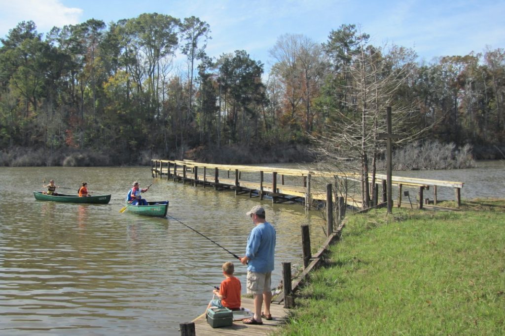 Bundick Lake RV Park Guests enjoying fishing from the shore and pier and paddling canoes at Bundick Lake Retreat & RV Park in DeRidder, Louisiana.