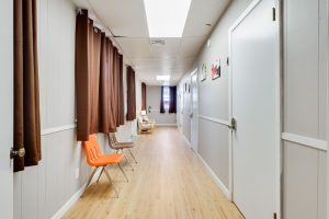 Bundick Lake RV Park Bright hallway at Bundick Lake Retreat and RV Park in DeRidder LA with wood floors, white doors, brown curtains, and seating area.