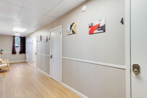 Bundick Lake RV Park Bright hallway at Bundick Lake Retreat and RV Park in DeRidder, Louisiana with wood floors, beige walls, white doors, and art decor.