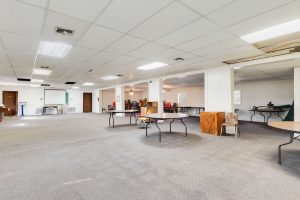 Bundick Lake RV Park Spacious event room at Bundick Lake Retreat and RV Park in DeRidder, LA with tables, chairs, projector screen, and doors.