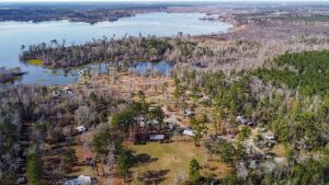 Bundick Lake RV Park Aerial view of Bundick Lake Retreat and RV Park in DeRidder, Louisiana with forested land, scattered homes, and lake inlets.